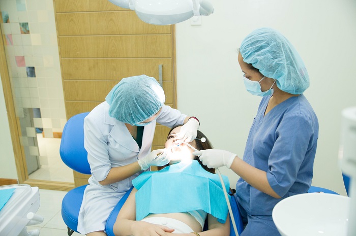 Bác sĩ tiến hành gắn khí cụ nha khoa lên răng - Nha Khoa KIM