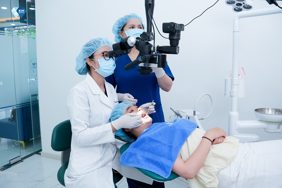 Bác sĩ Nha Khoa Kim đang sử dụng kính hiển vi nha khoa để điều trị cho bệnh nhân